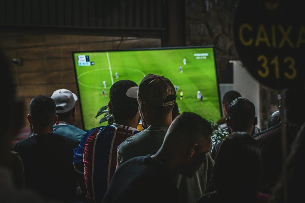 People at a bar watching a FIFA soccer game.